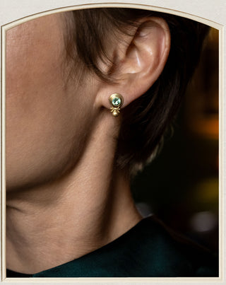 close up of model wearing green garnet earrings set in gold